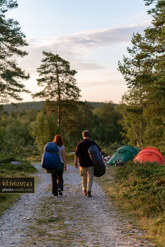 Couple camping under a star-filled sky with camping gear