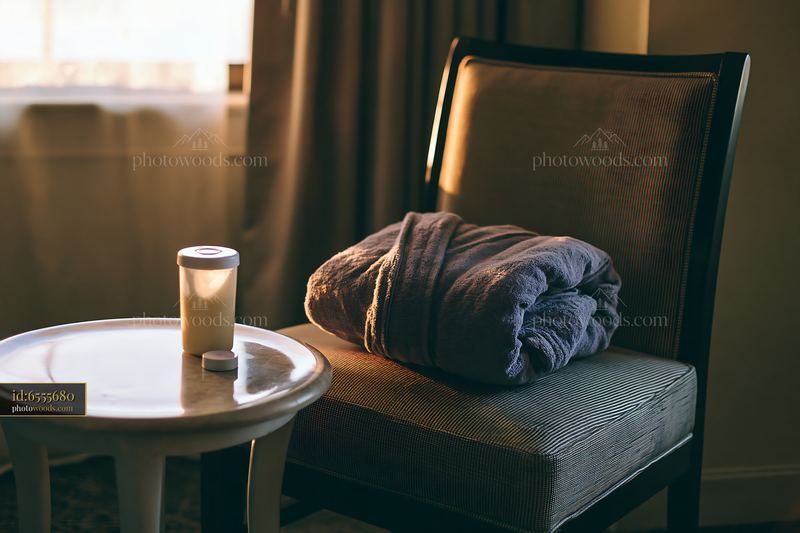 Cream dose beside a folded robe on a chair