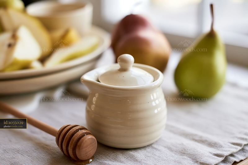 Cream dose beside honey dipper on a table with fruit