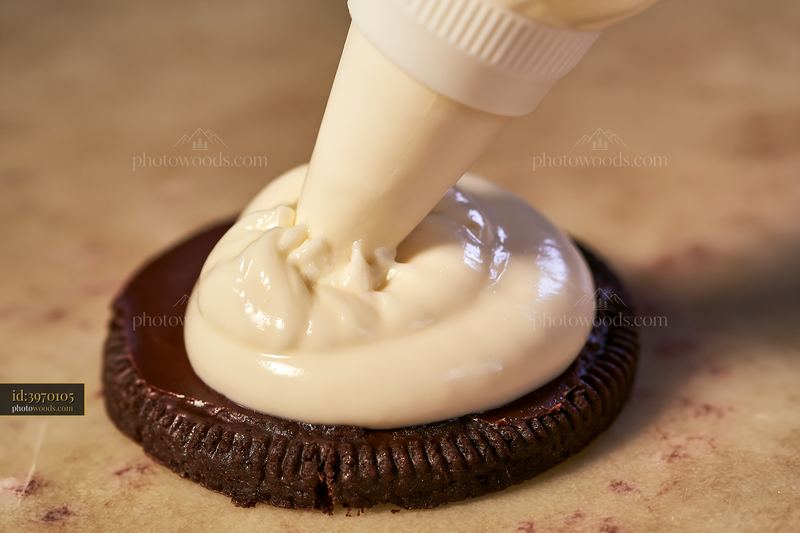 Cream dose with smooth glossy texture applied to an Oreo cookie