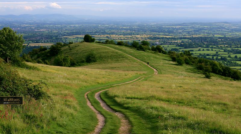 Curving path through green landscape with distant hills and fields