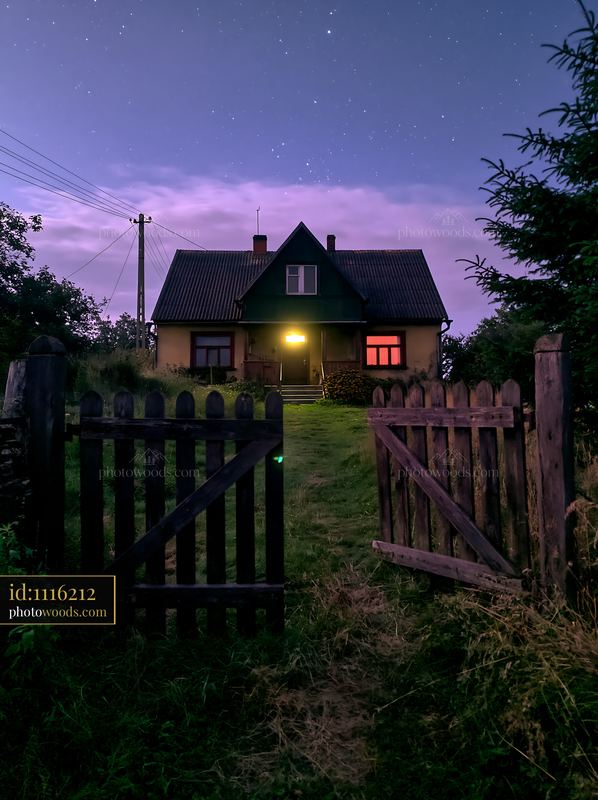 Farmhouse beneath night sky with stars and open gate