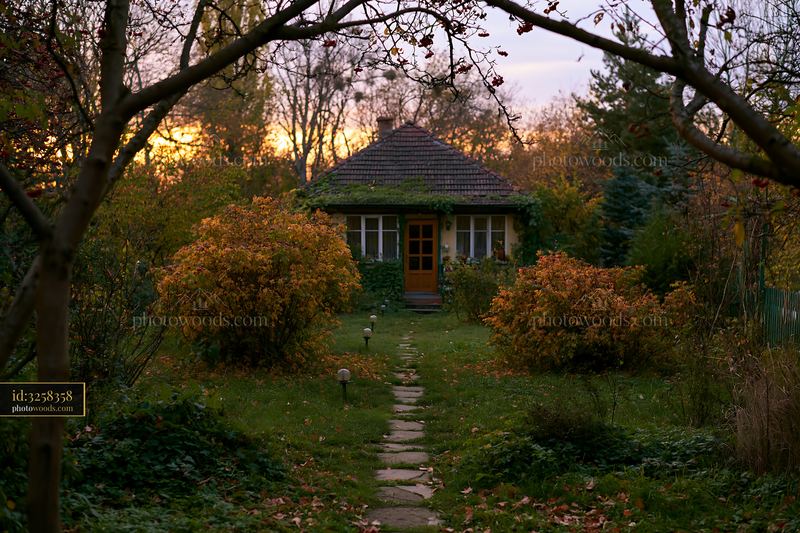Empty garden house with pathway lights at sunset