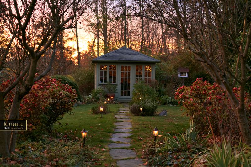 Empty garden house with pathway lights surrounded by trees