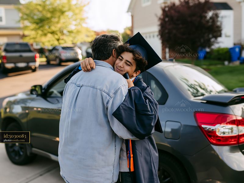 Graduation hug between graduate and proud parent near car