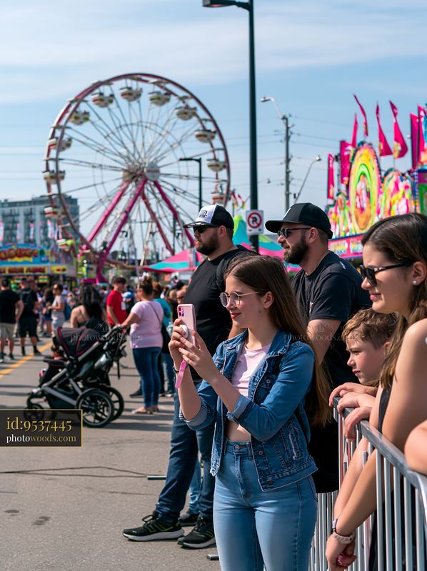 Family waiting in line at a fair near a ferris wheel