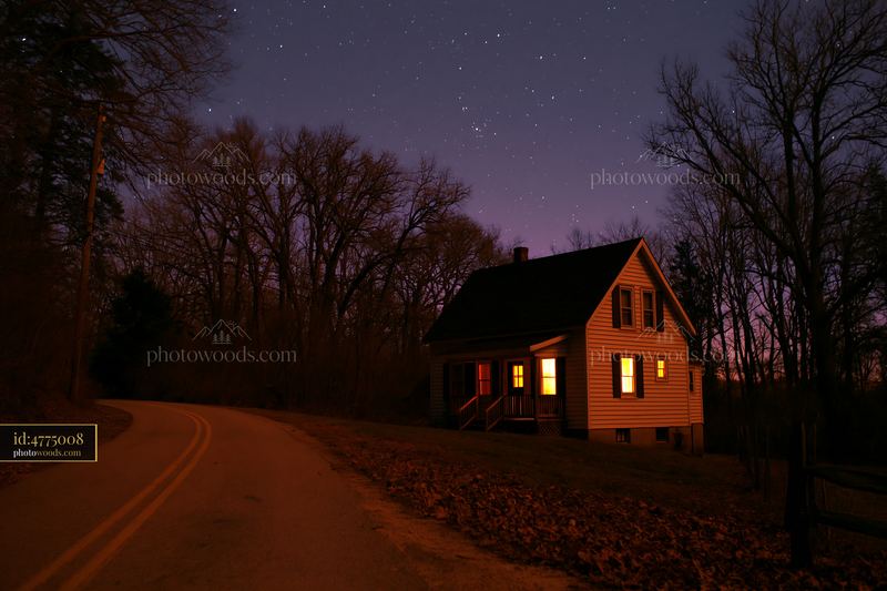 Home beneath stars photographed at night with a winding road