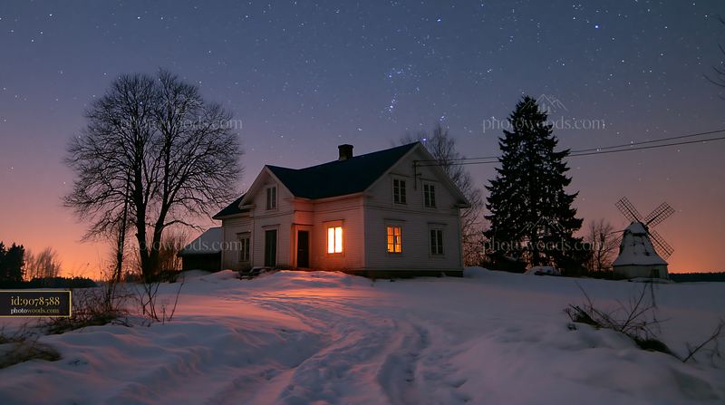 Snowy house under stars at night with glowing window