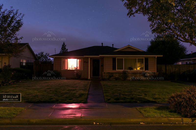 House under stars during blue hour with warm light from window