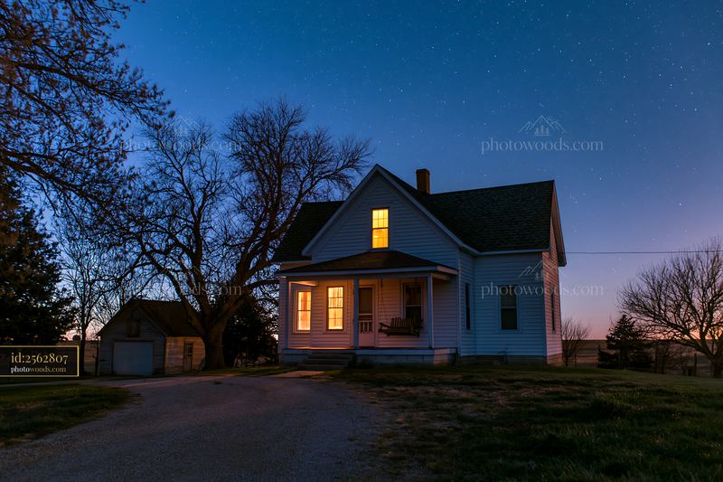 House with porch swing under starry sky at dusk