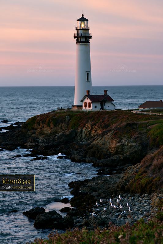 Lighthouse near a rocky tide pool at sunset