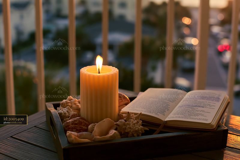 Candle surrounded by seashells on a wooden tray