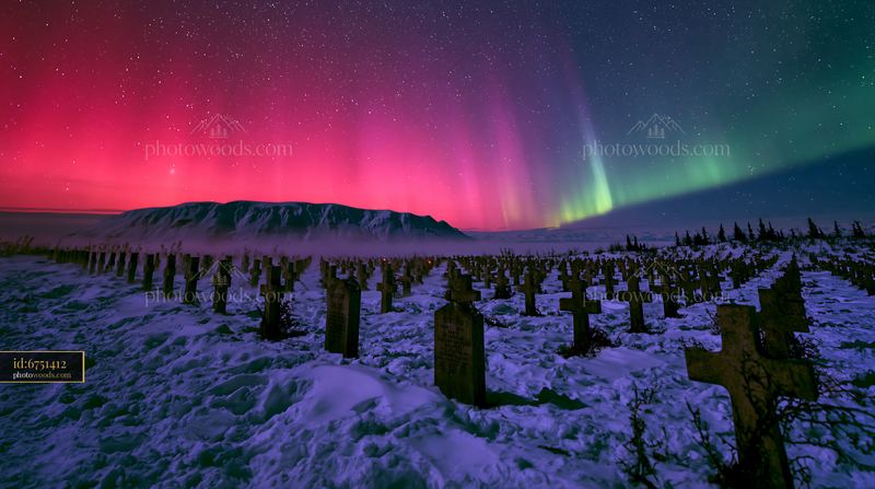 Military cemetery beneath northern lights at night