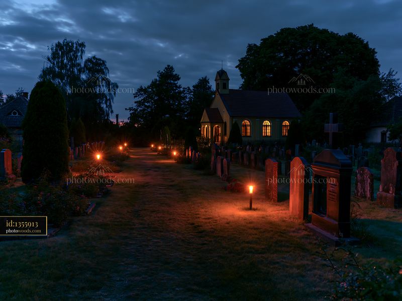 Memorial cemetery illuminated under night sky with candles