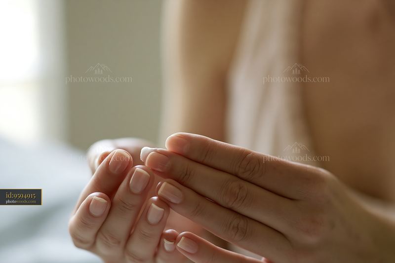 Applying cream for sensitive skin on hands in a bright room