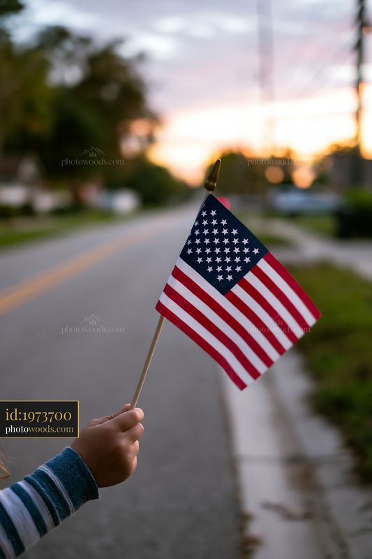 American flag waving in the hand at dawn along the street