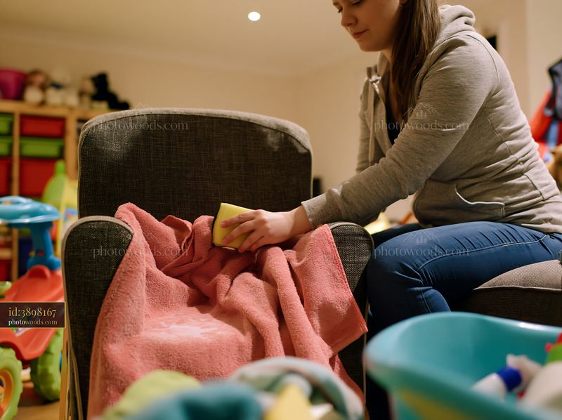 Cleaning upholstery stain with a sponge in a living room