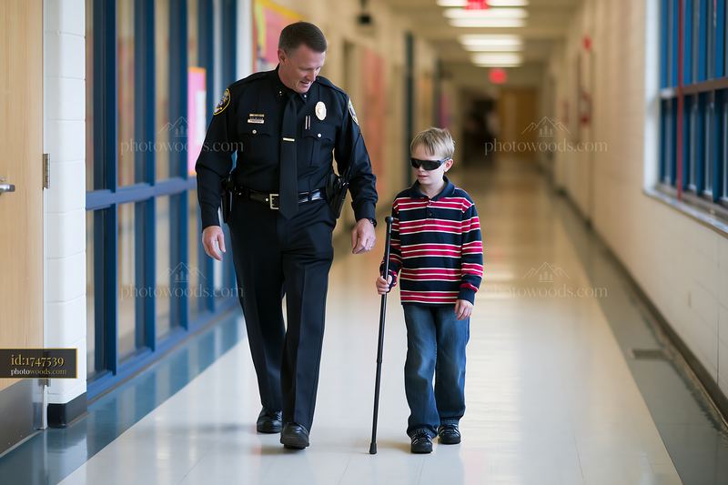 Police chief walking with young boy in school hallway