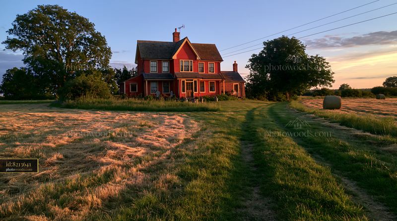 Restored farmhouse exterior with a winding path and fields