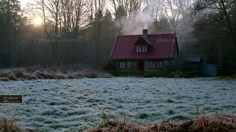 Rural cottage with chimney smoke surrounded by frost
