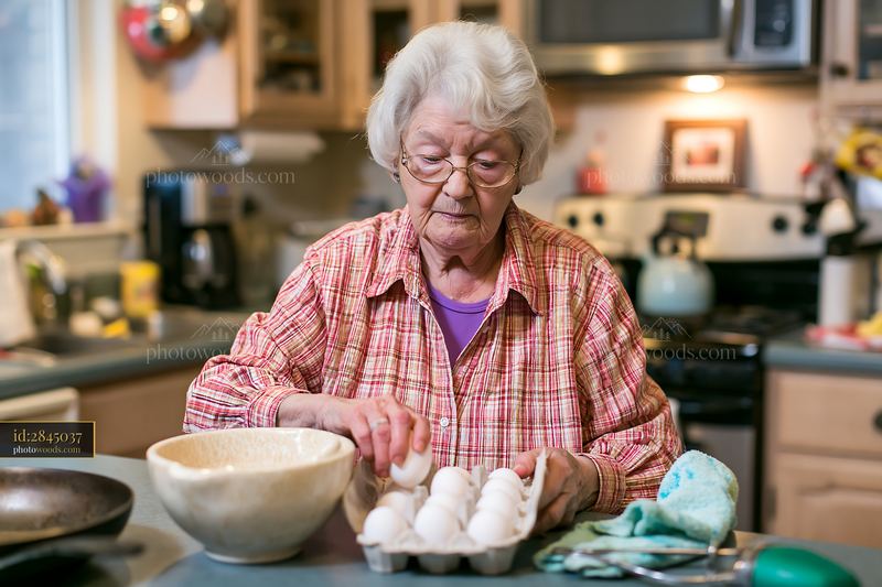 Senior woman with dementia preparing simple food in her kitchen