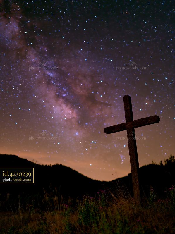 Silhouetted cemetery cross with Milky Way background
