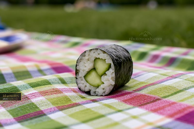 Cucumber maki roll on a picnic blanket in a green setting