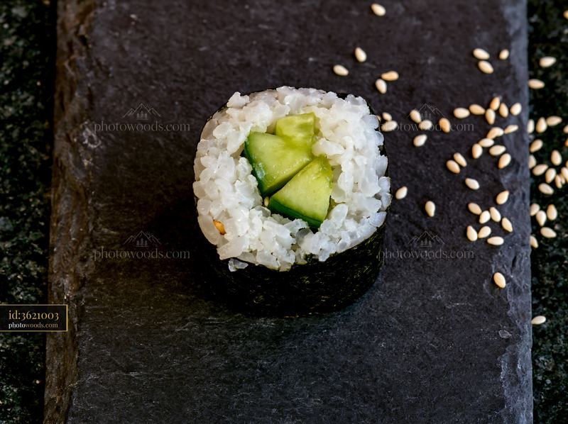Single sushi piece on black slate surface