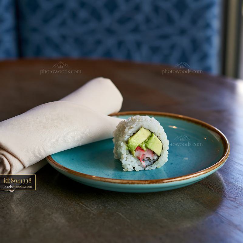 Single sushi roll served on a ceramic plate with a napkin