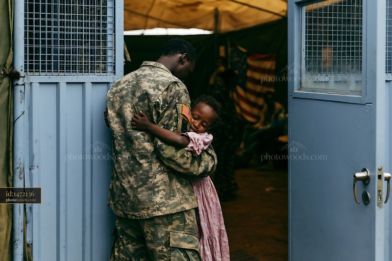 Soldier hugs child in a shelter setting