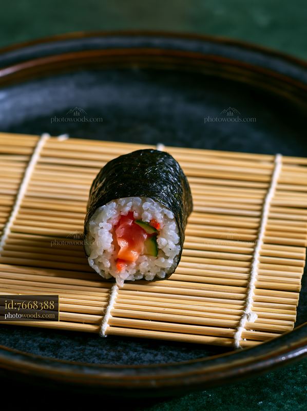 Single sushi roll on bamboo mat