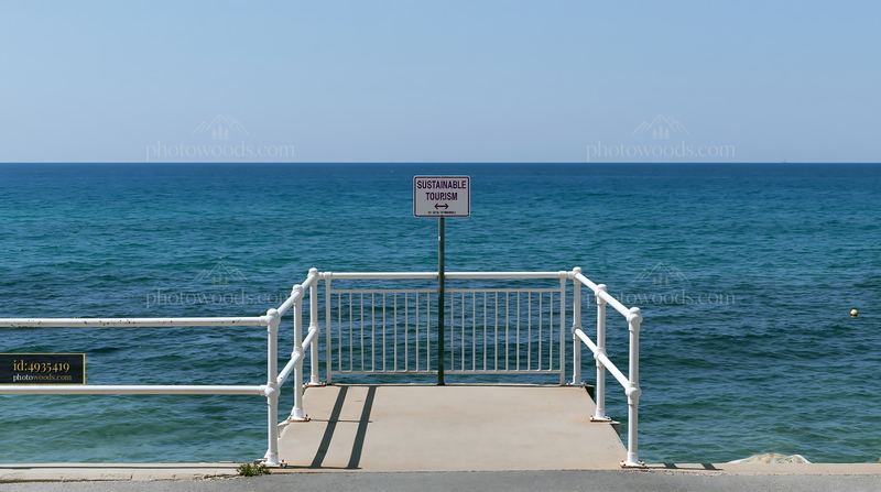 Coastline with sustainable tourism sign near the water's edge