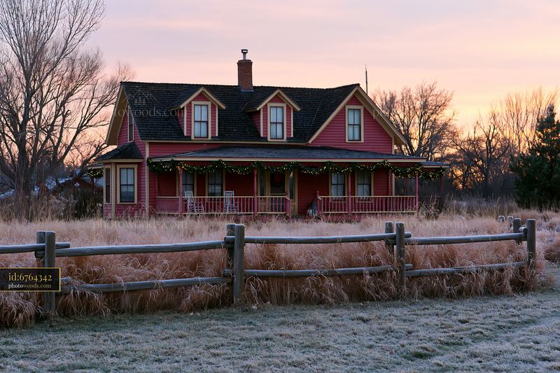 Traditional farmhouse with holiday garlands at sunset
