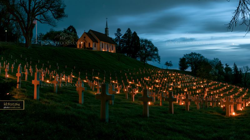 Nighttime military cemetery panorama with illuminated grave markers