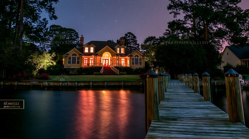 Villa beneath a star-filled sky with a serene dock and water