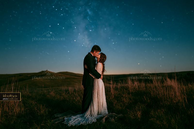 Couple kissing under a star-filled sky at night