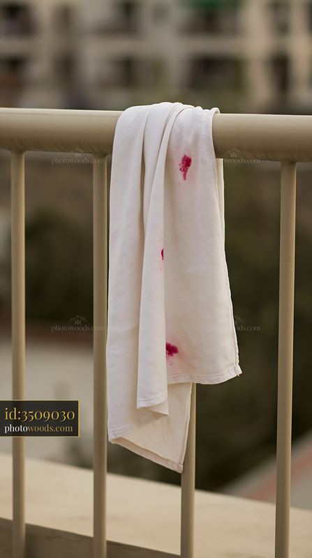 White cloth stained with colored liquid hanging on a railing