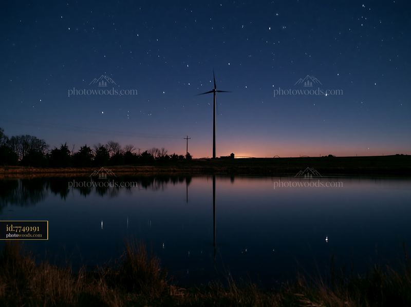 Starry night above a rural wind turbine in a calm setting