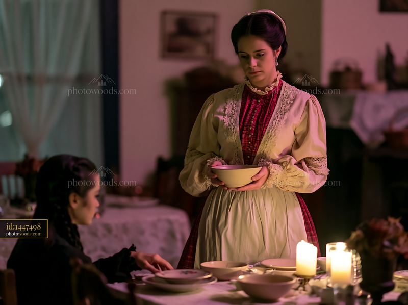 Woman in traditional dress holding a handmade ceramic bowl at dinner