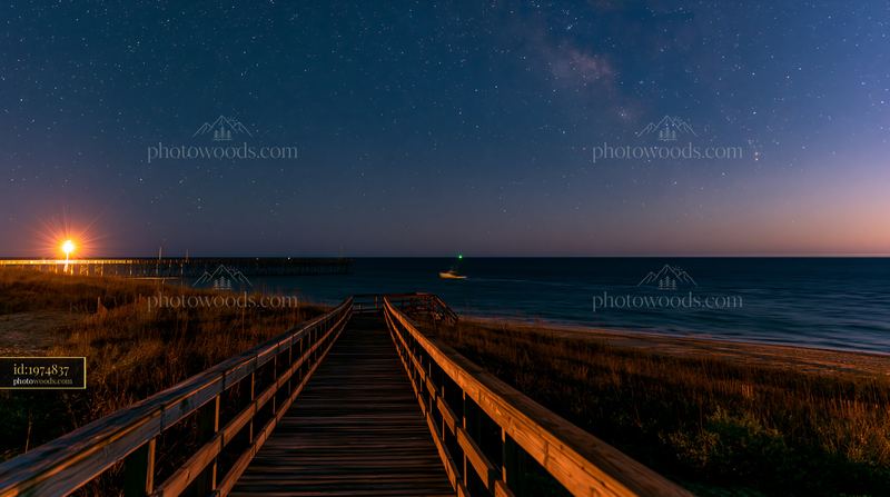 Starry night over a coastal boardwalk with wooden pathway