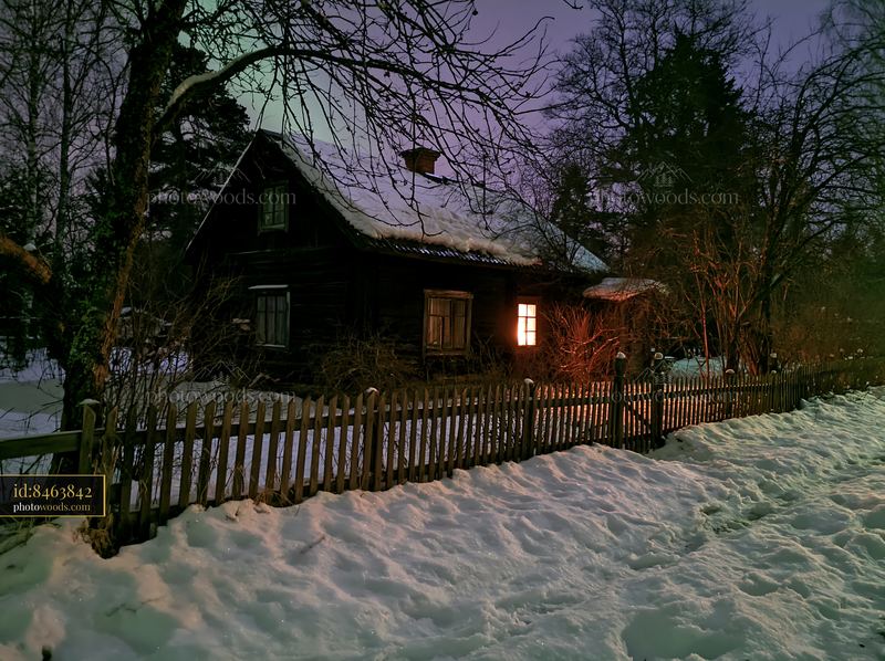 Cottage under northern lights with snow and trees