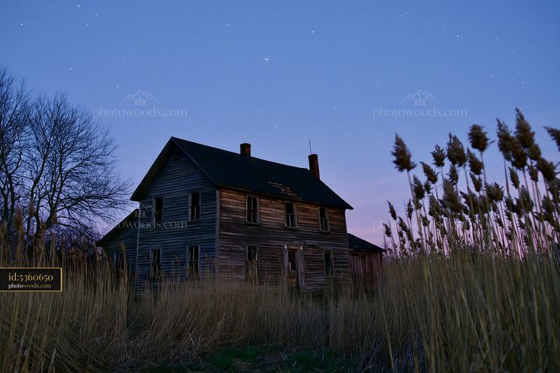 House under stars during blue hour in a quiet field