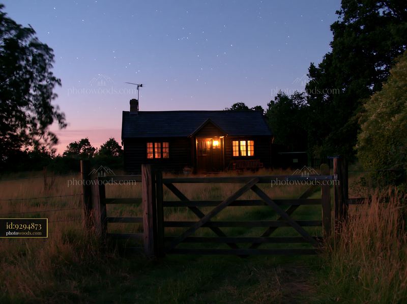 House in a meadow beneath stars at dusk