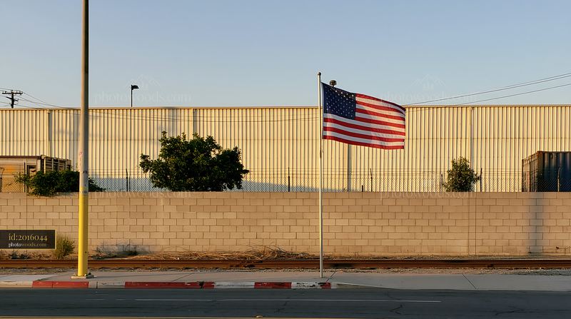 American flag outside factory with building in background