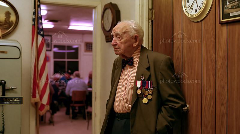 Veteran wearing medals stands by a door in a community center