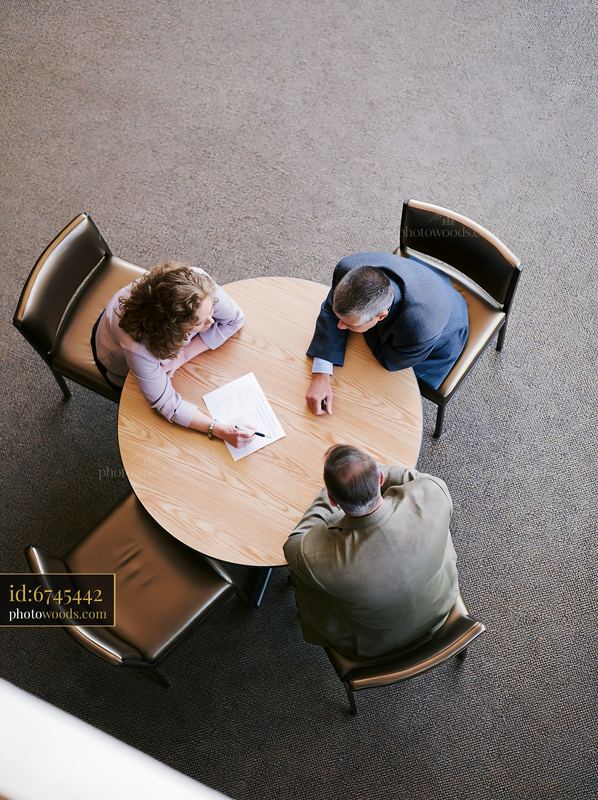 Businesswoman Reviewing Contract with Advisors at Office Table