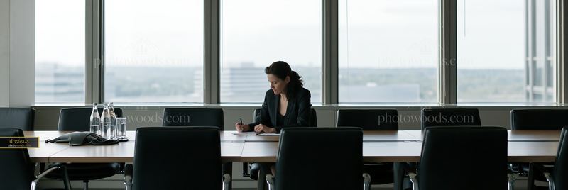 Businesswoman taking notes at a conference table