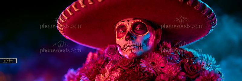 Skull-painted person in sombrero surrounded by vibrant flowers