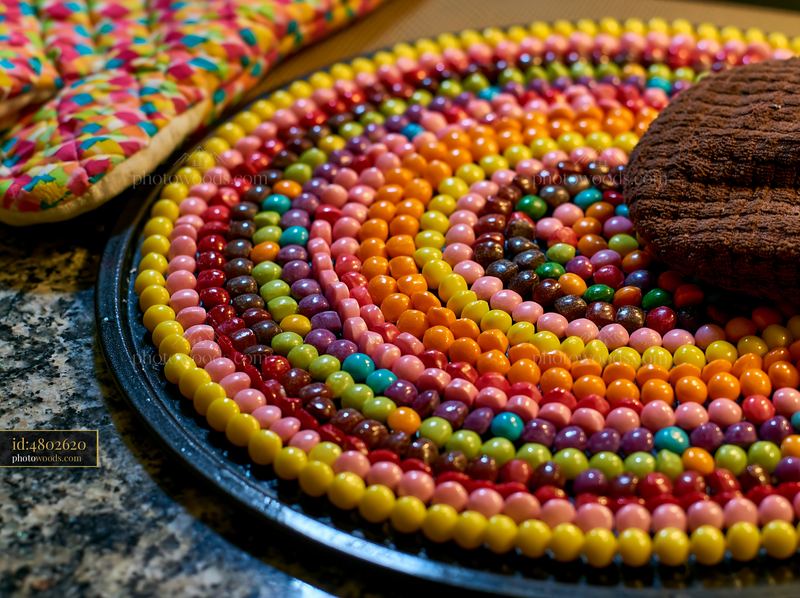 Colorful candy pieces forming spiral on a textured surface