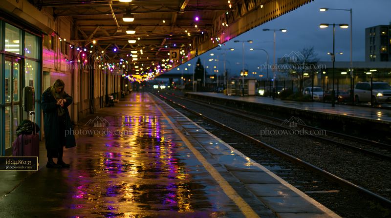 Christmas lights reflecting on a wet railway platform